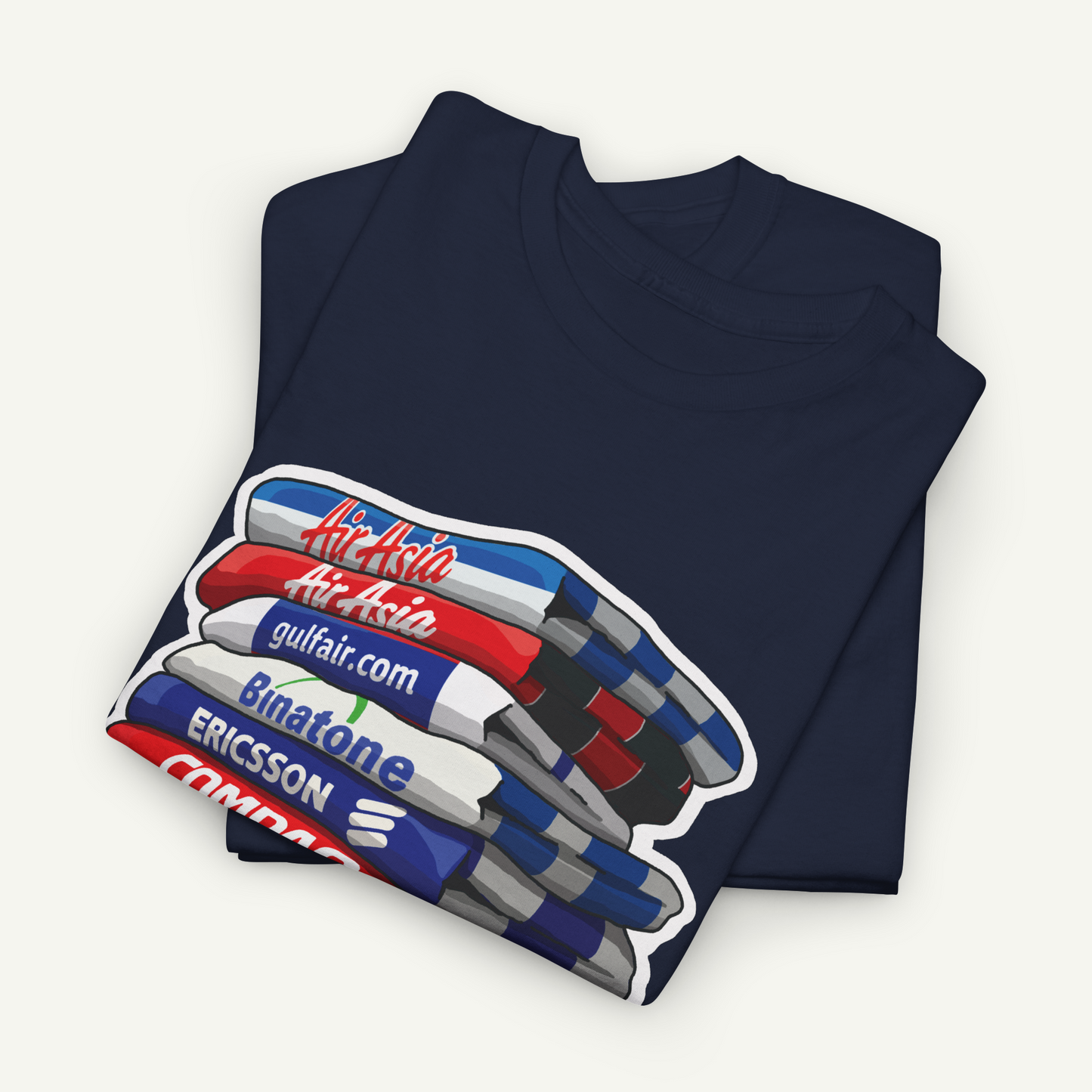 A navy blue t-shirt with a graphic design depicting a stack of books or magazines with various text elements on the covers.