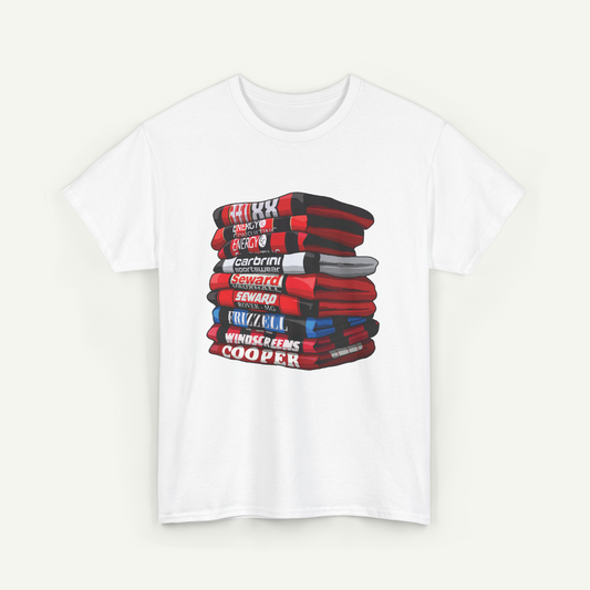A white t-shirt with a graphic design depicting a stack of books or magazines with various titles and authors' names printed on the covers.