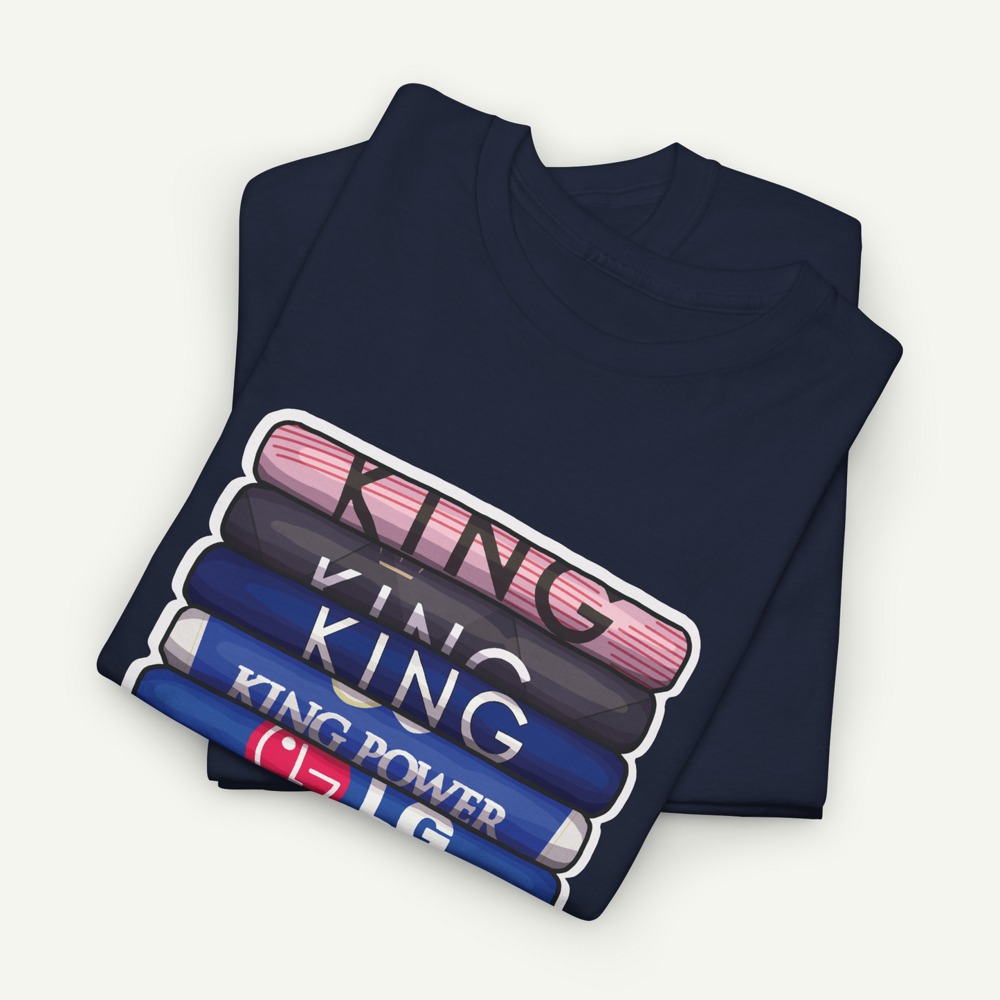 A navy blue t-shirt with a graphic design featuring the text "KING" in a stacked arrangement, with each letter in a different color.