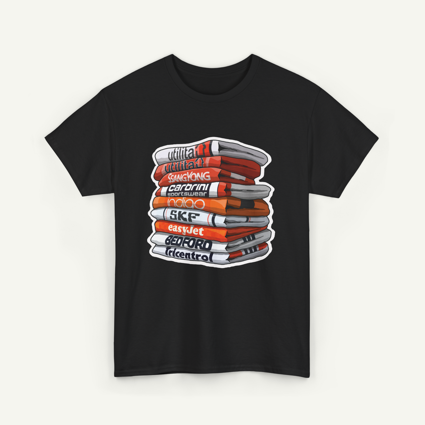 A black t-shirt with a graphic design depicting a stack of books or magazines with various titles and text.