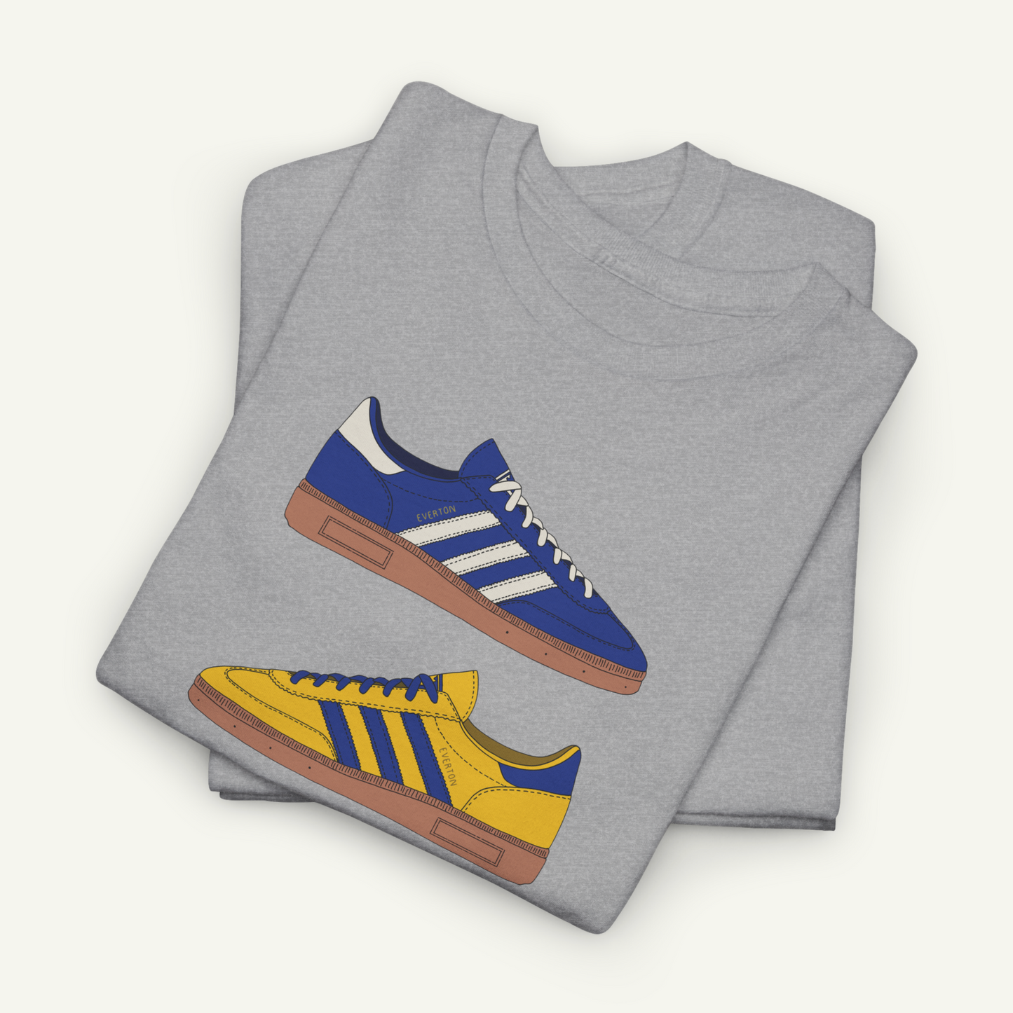 A gray t-shirt with a graphic design of two different colored Adidas sneakers, one blue and one yellow, printed on it.