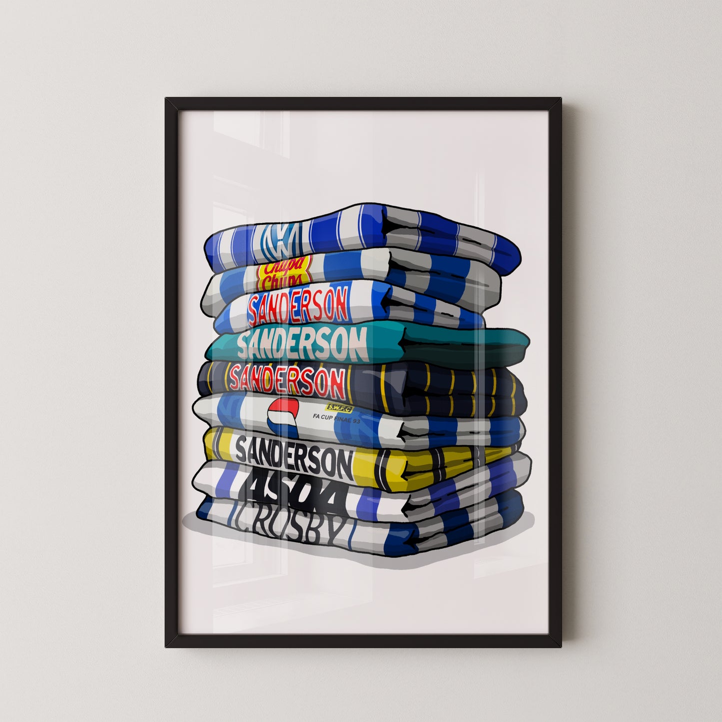 A framed illustration of a stack of rugby towels with various team names and logos printed on them.