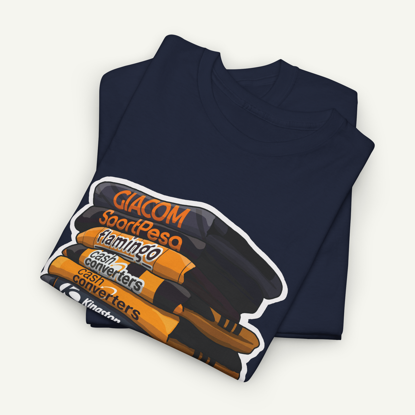 A navy blue t-shirt with a graphic design depicting a stack of books or magazines with the text "Giacom SoortPesa Flamingo Cash Converters" printed on it.