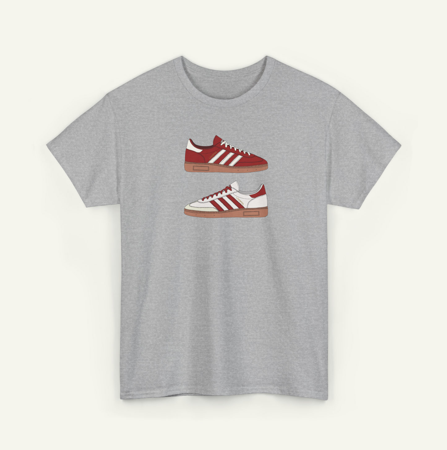 A gray t-shirt with a graphic design of two red and white Adidas sneakers.