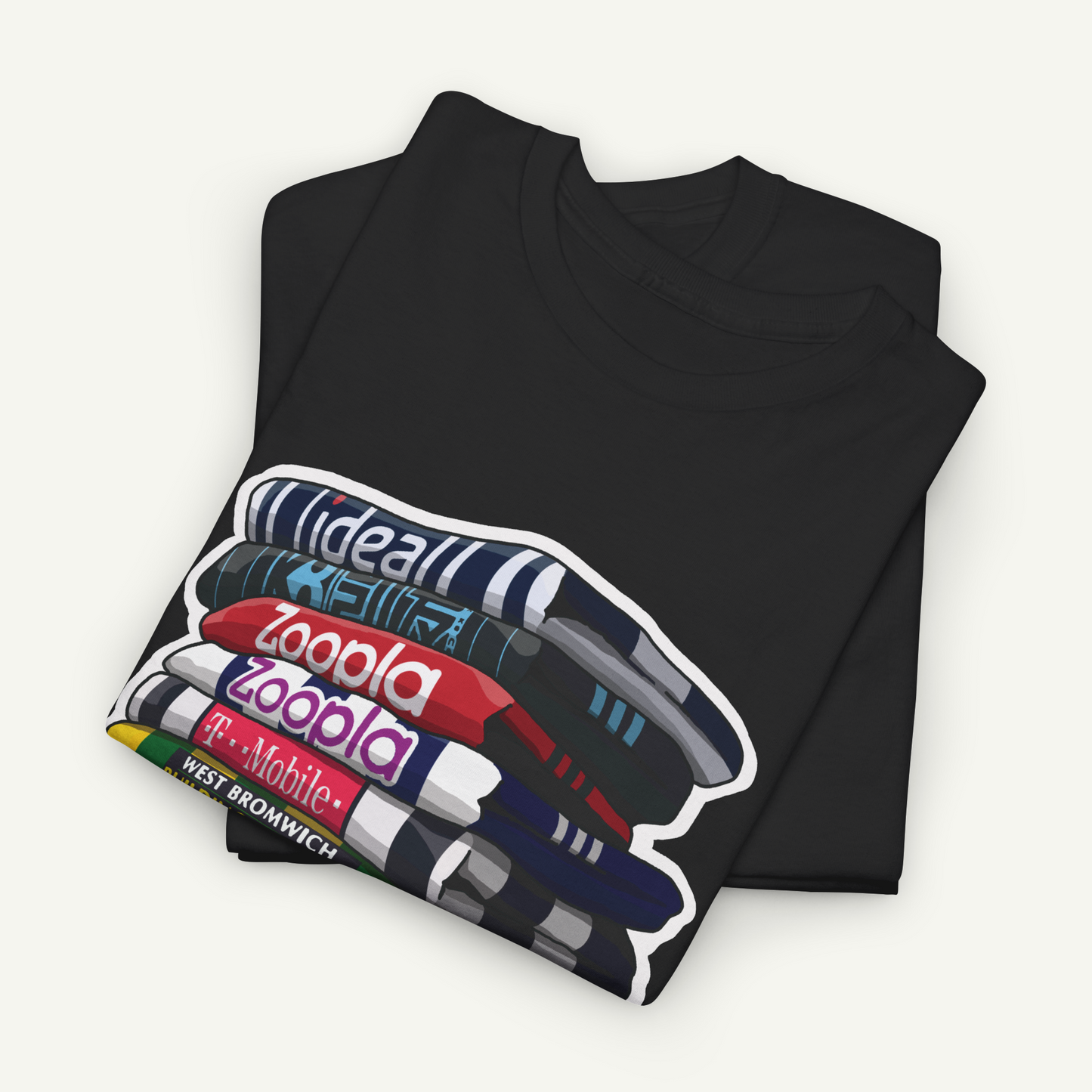 A black t-shirt with a graphic design depicting a stack of books with the text "ideal zoopla" printed on them.