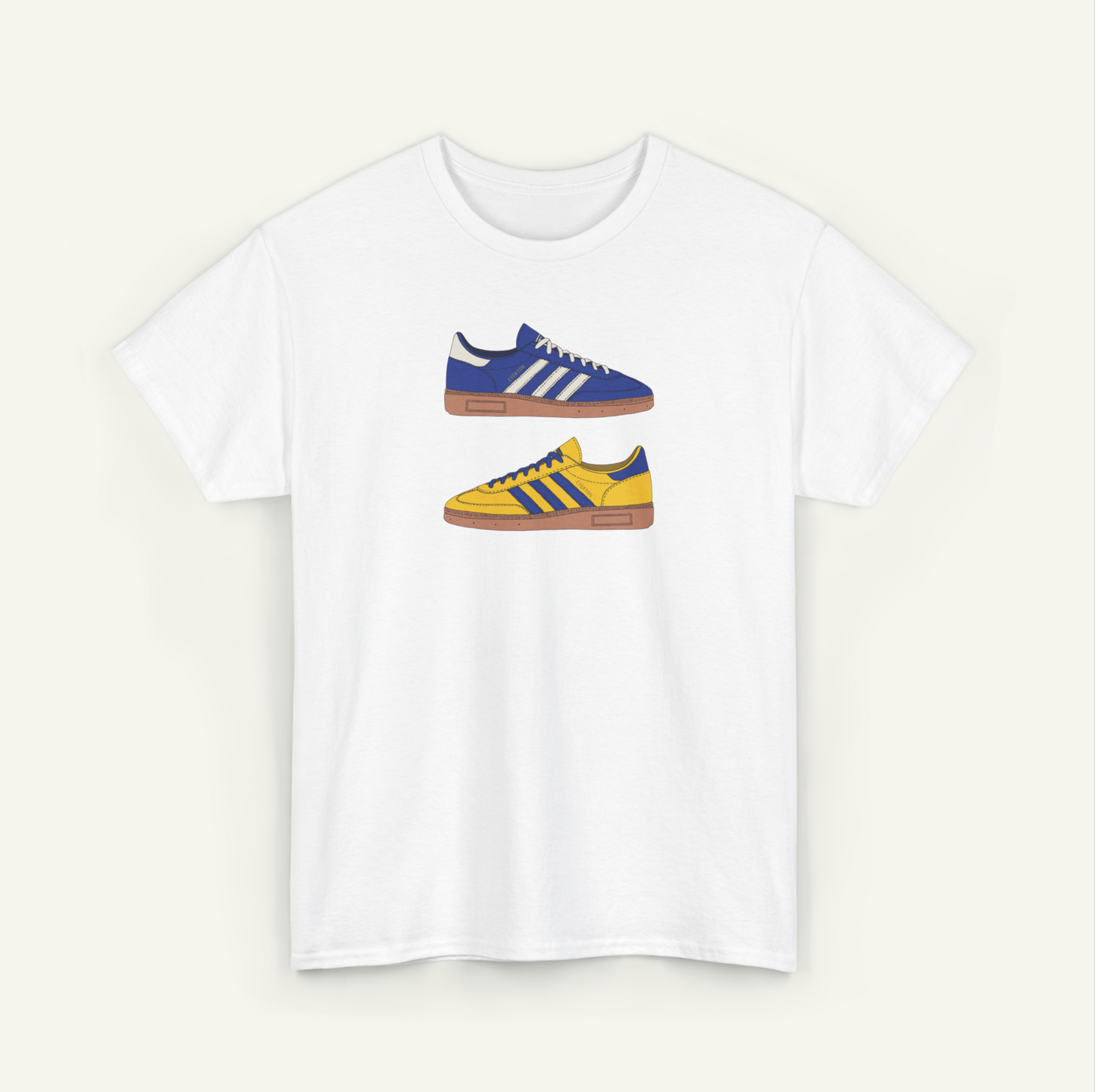 A white t-shirt with a graphic design of two Adidas sneakers in blue and yellow colors.