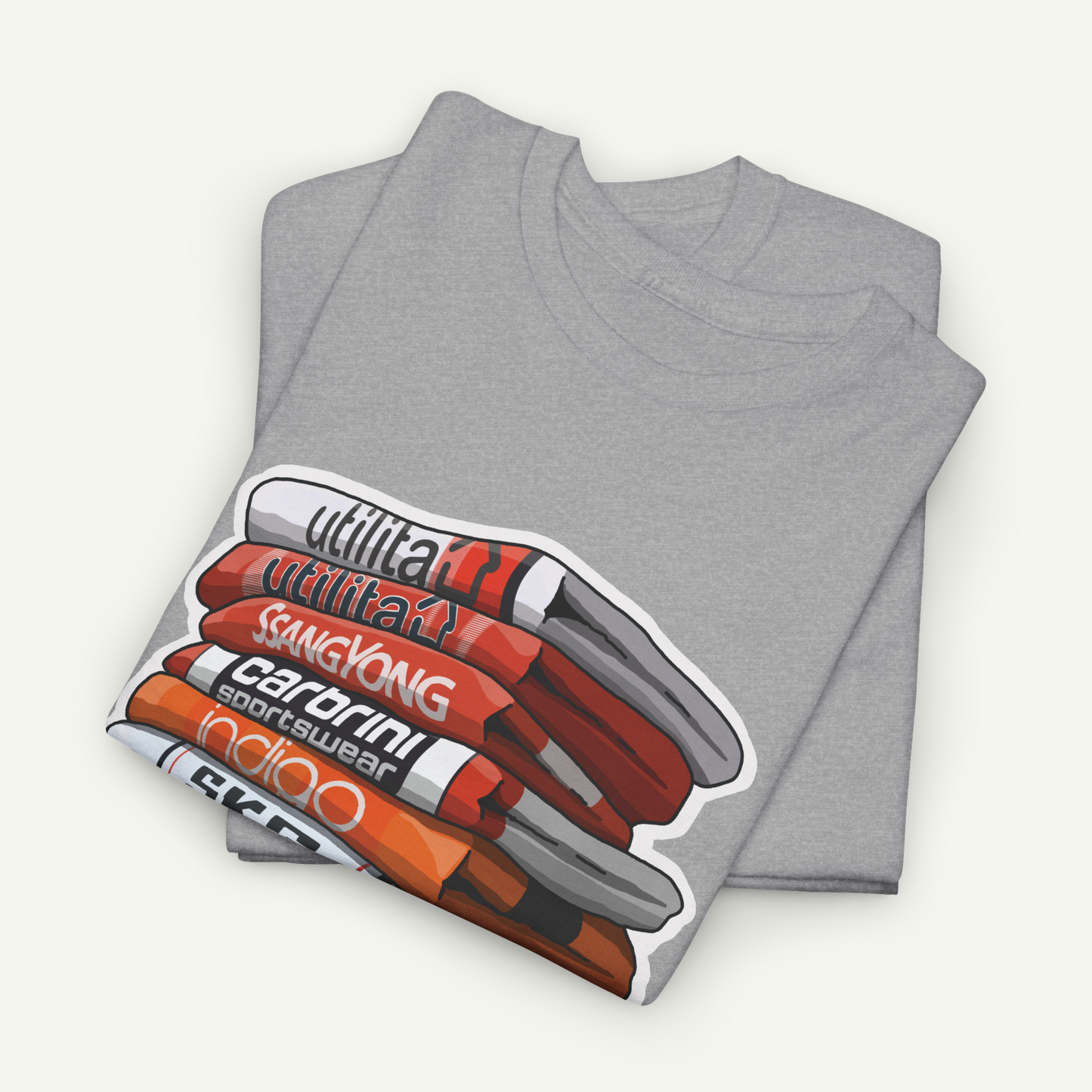 A gray t-shirt with a graphic design depicting a stack of books or magazines with various text titles.