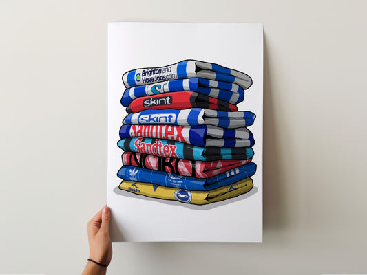 A hand is holding up a poster with a stack of colorful towels, each displaying a different brand logo.