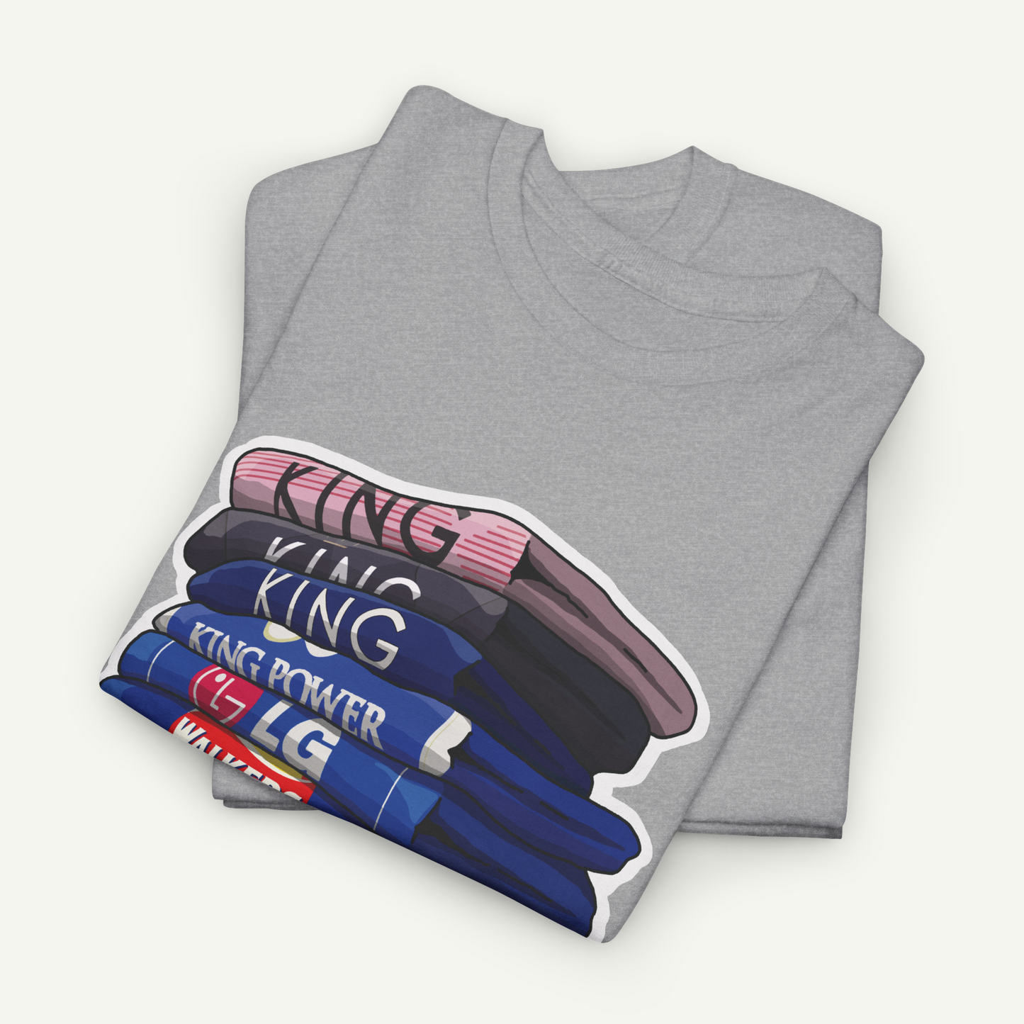 A gray t-shirt with a graphic design depicting a stack of books or magazines with the word "KING" printed on them.