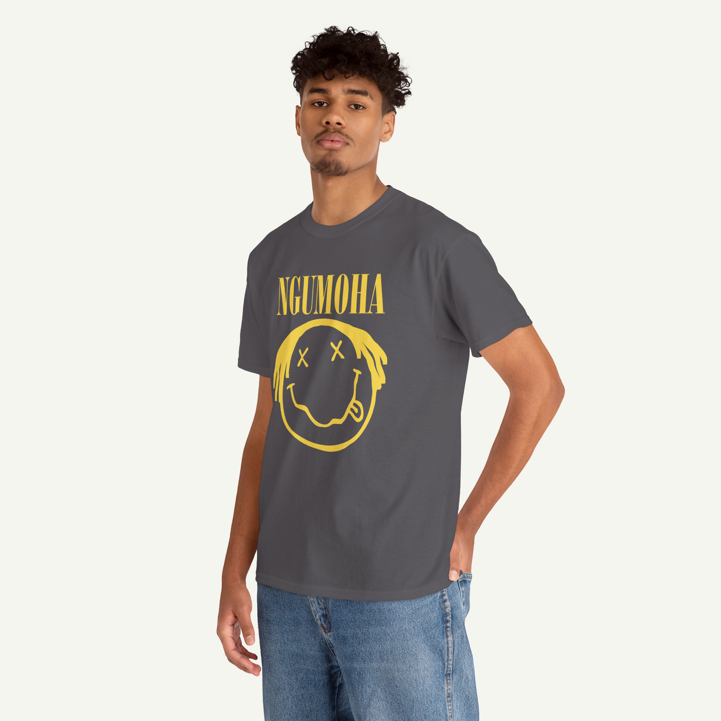 A young man wearing a gray t-shirt with a yellow smiley face graphic and the text "NGUMOHA" printed on it.