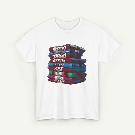 A white t-shirt with a graphic design depicting a stack of colorful books.