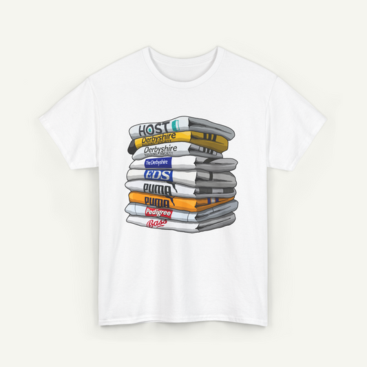 A white t-shirt with a graphic design depicting a stack of various colored books or magazines, with the text "Hostile" and "Derbyshire" printed on the top book.