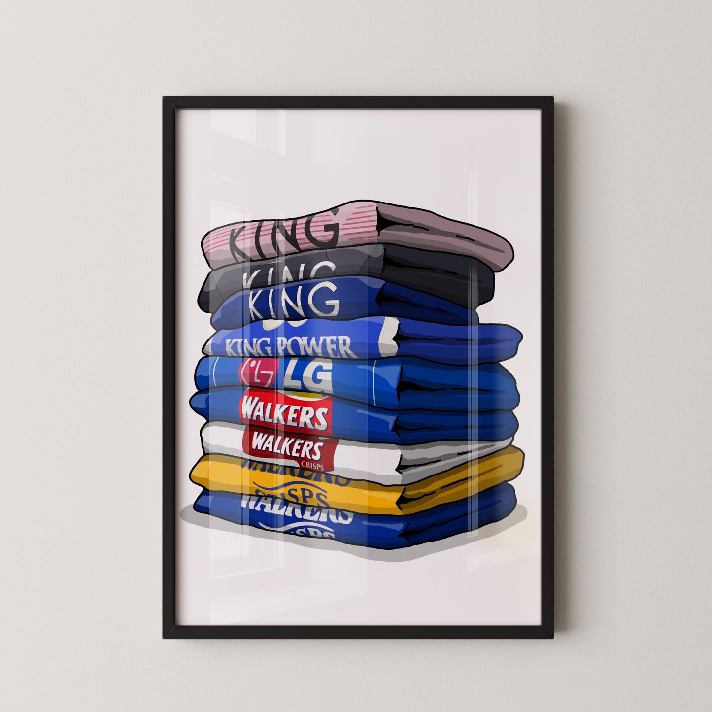 A framed illustration of a stack of folded shirts with various text printed on them.