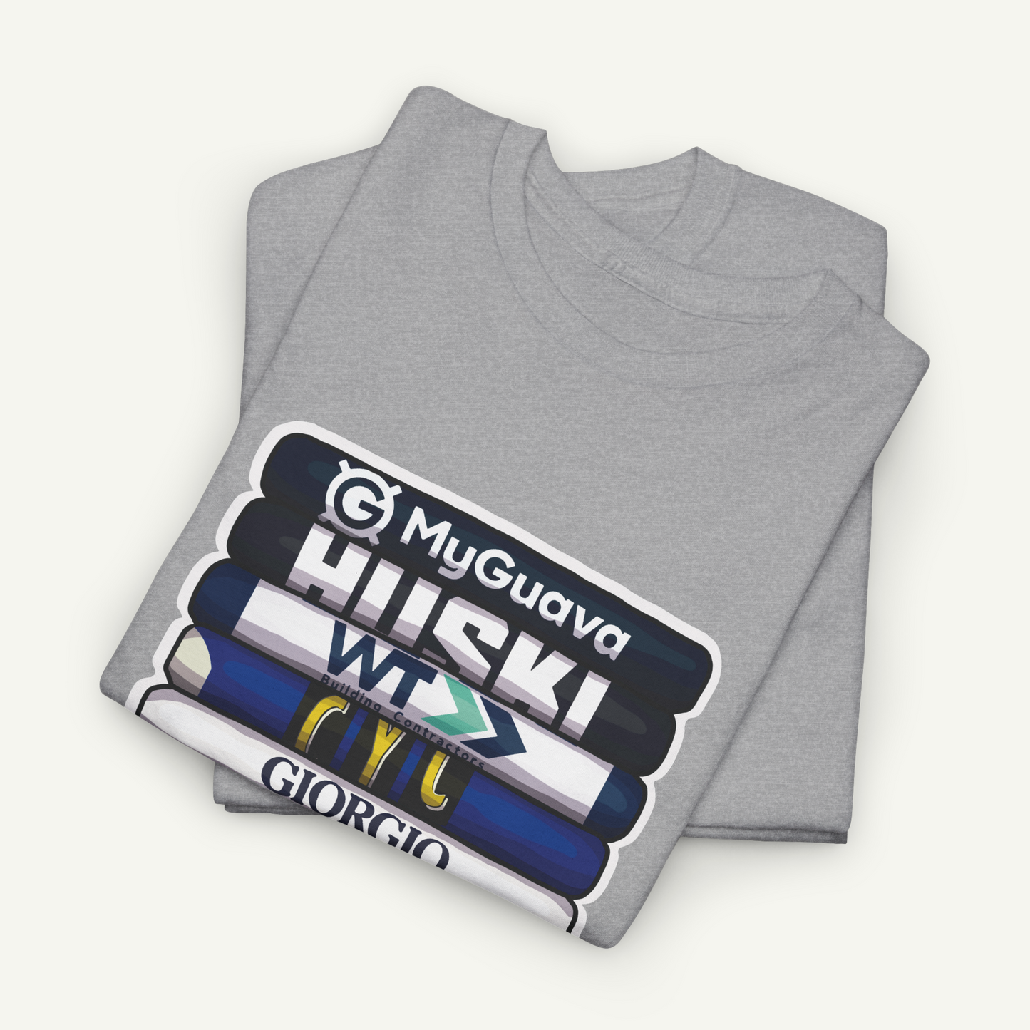 A gray t-shirt with a graphic design featuring a stack of books with various text labels on the spines.