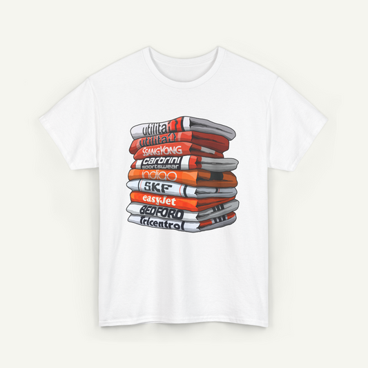 A white t-shirt with a graphic design depicting a stack of books or magazines with various colored covers.