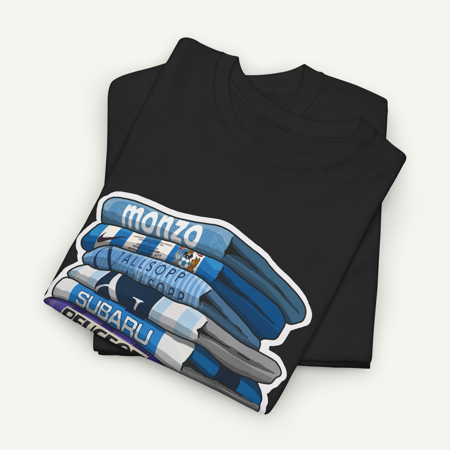 A black t-shirt with a graphic design depicting a stack of blue and white striped towels, with the word "monzo" written on them.