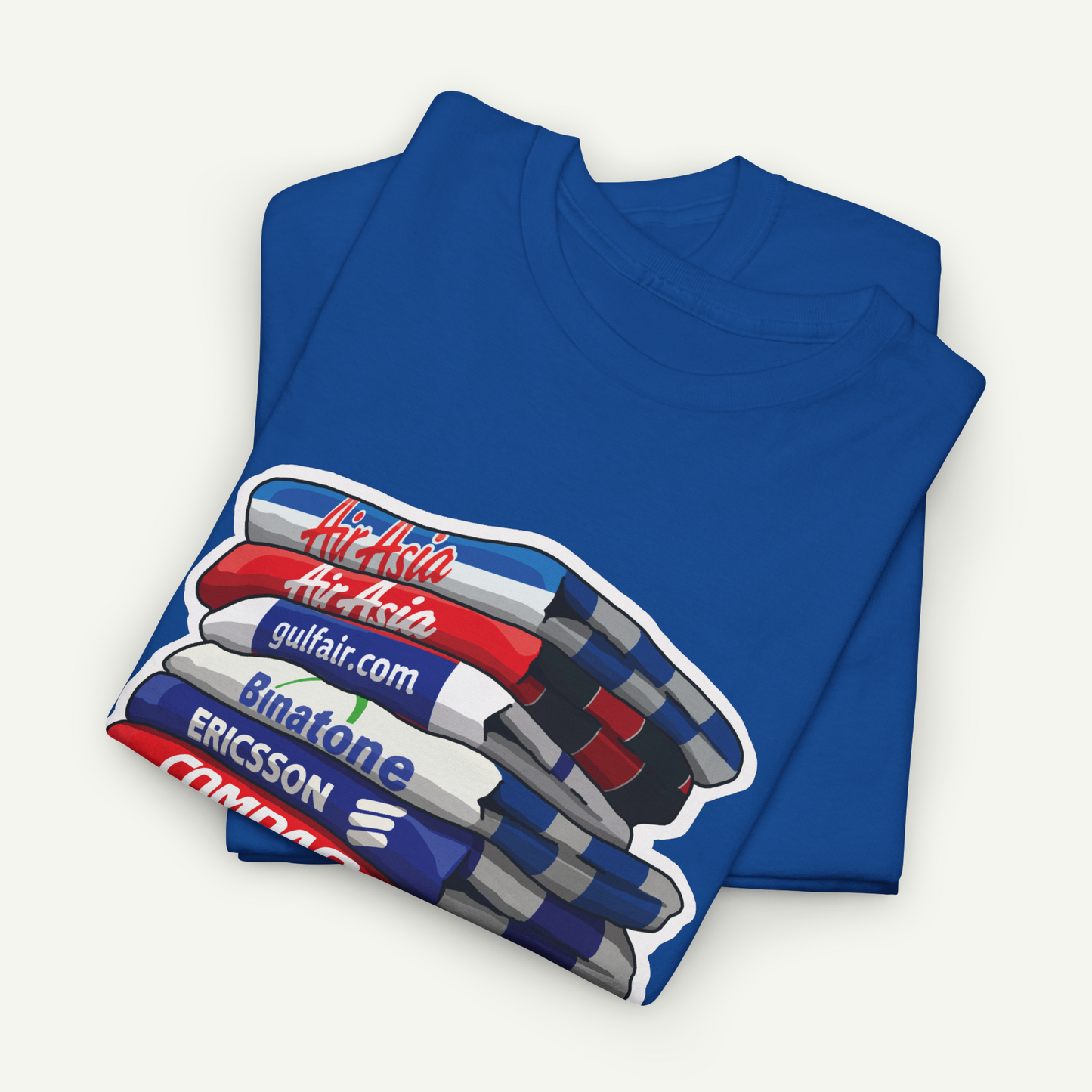 A blue t-shirt with a graphic design depicting a stack of books or magazines with various text elements on them.