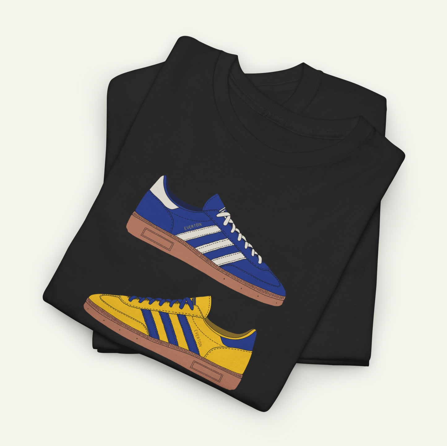 A black t-shirt with a graphic design of two Adidas sneakers, one blue and one yellow, printed on it.