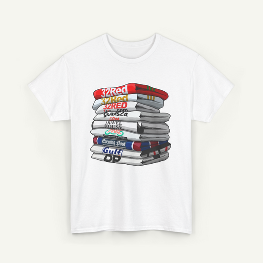A white t-shirt with a graphic design depicting a stack of books with various text labels on the spines.