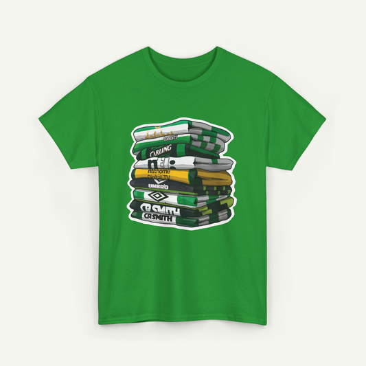 A green t-shirt with a graphic design depicting a stack of books or magazines with various text labels on the spines.