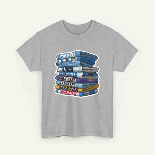 A gray t-shirt with a graphic design depicting a stack of books or magazines with various titles written on them.