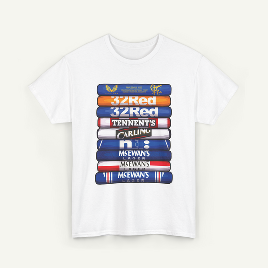 A white t-shirt with a graphic design featuring a stack of colorful books or book-like objects, each with a different logo or text on it.