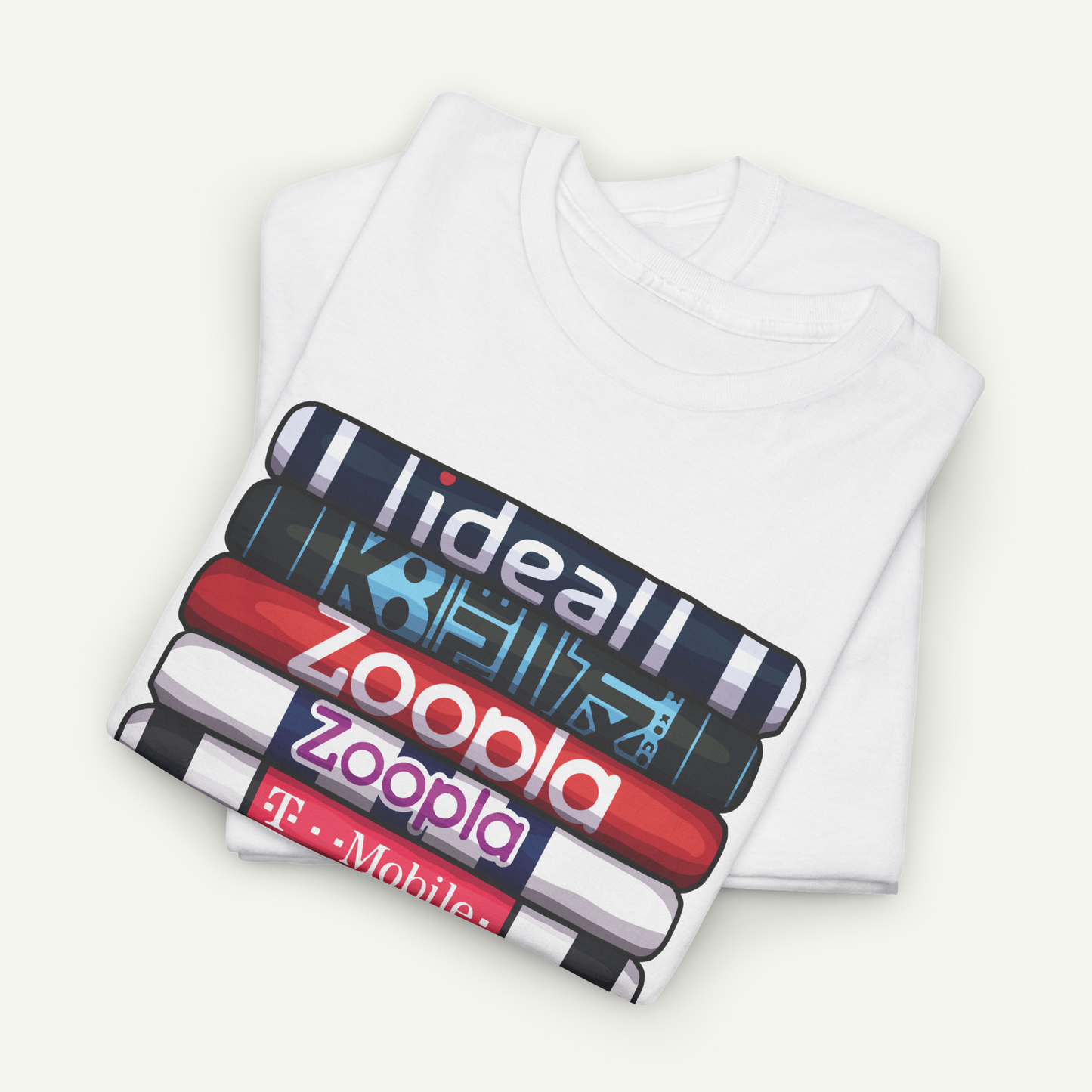 A white t-shirt with a graphic design featuring a stack of colorful books or magazines with the text "ideal zoopla mobile" printed on them.