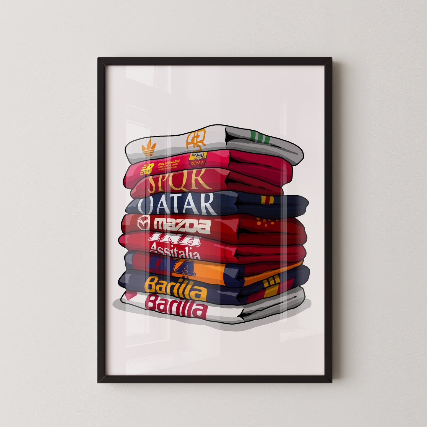 A framed illustration depicting a stack of colorful towels with various logos and text, including "Qatar", "Spur", "Mazda", "Barilla", and "Assistal".