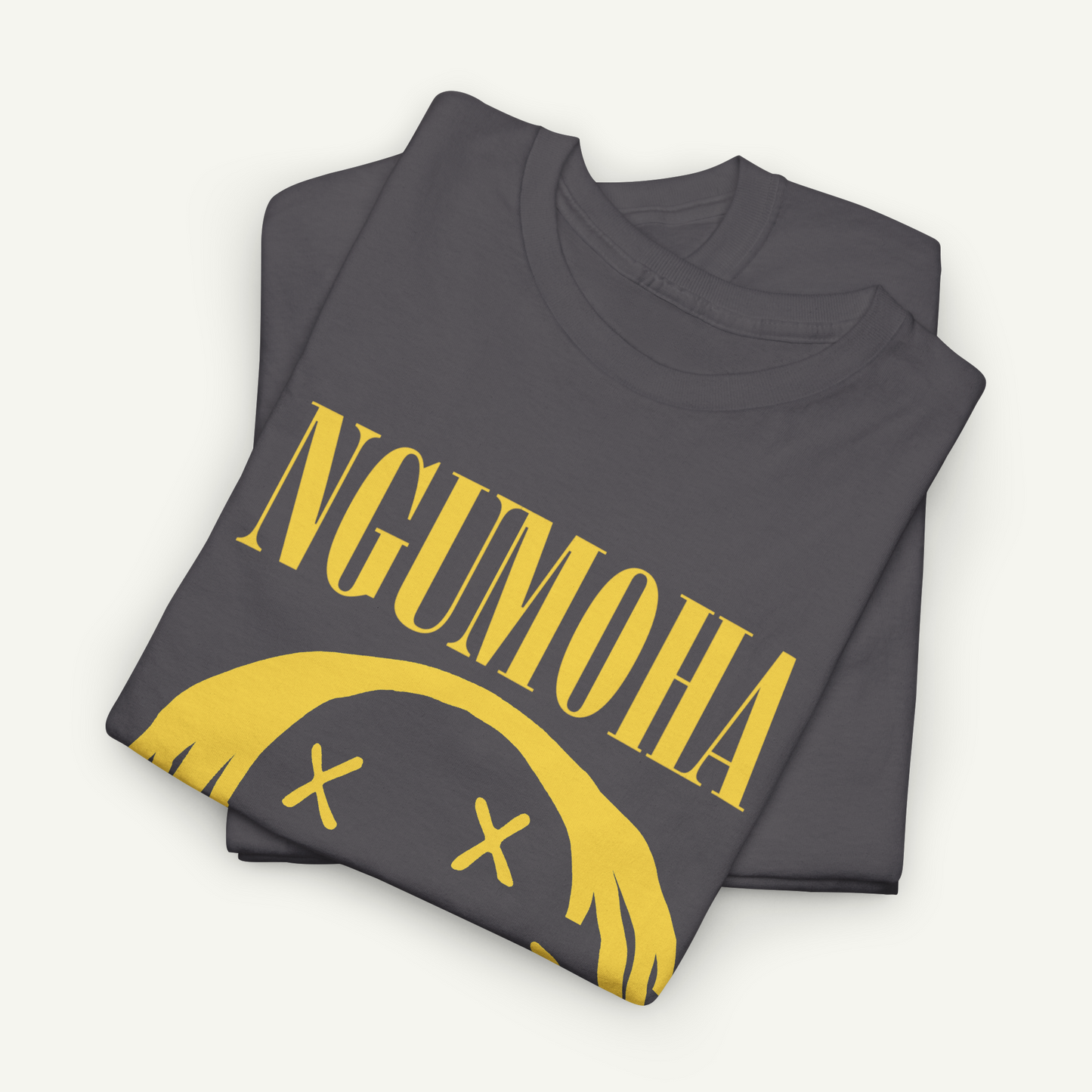 A gray t-shirt with the text "NGUMOHA" printed on it, along with a yellow graphic design featuring a yellow smiley face and three yellow x's.