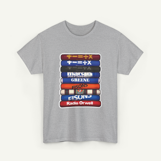 A gray t-shirt with a graphic design depicting a stack of colorful books or magazines with the names of various individuals or groups printed on them.