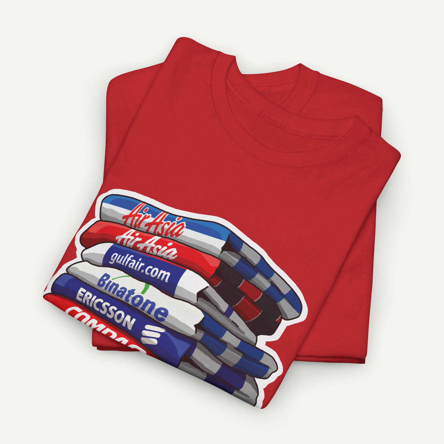 A red t-shirt with a graphic design depicting a stack of three books, each with a different colored cover.