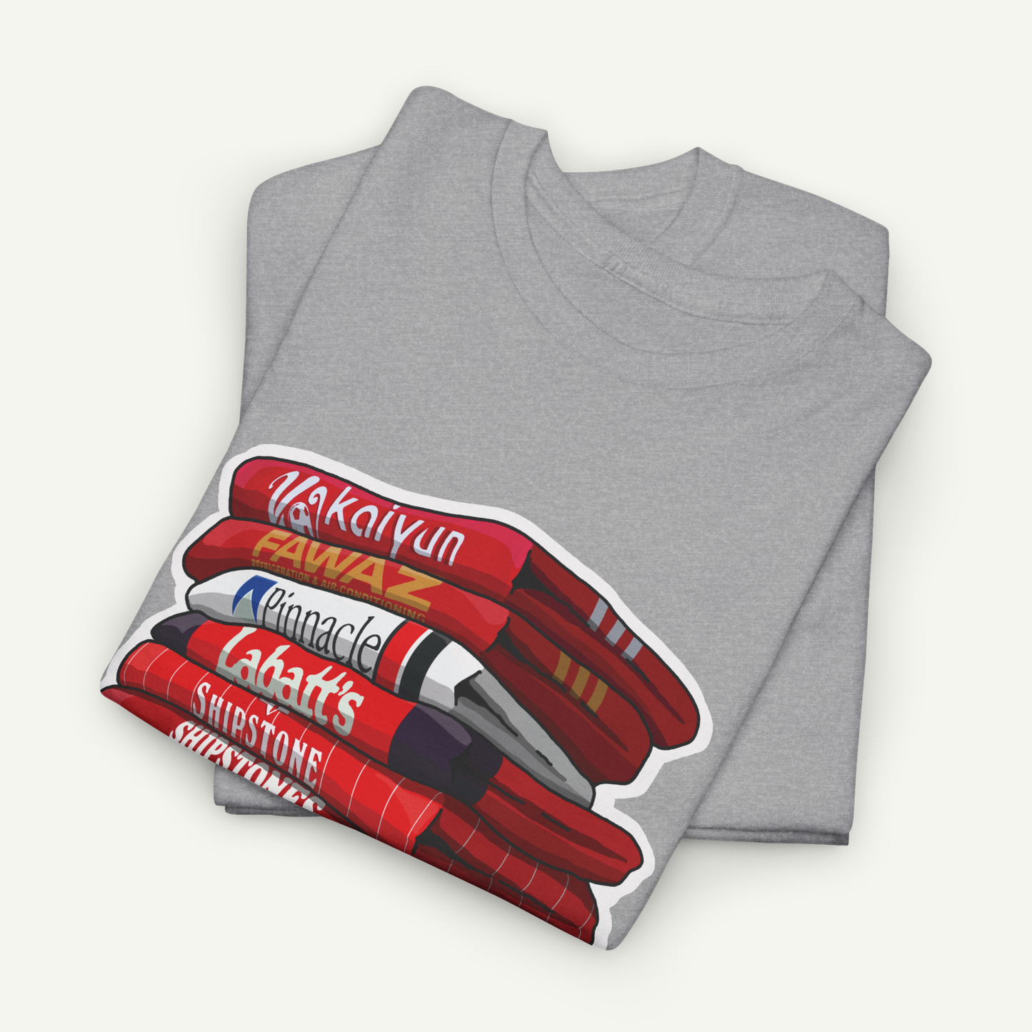 A gray t-shirt with a graphic design depicting a stack of red and white markers with the text "Vakalvin", "Fawaz", "Pinnacle", "Labatt's", and "Shiststone!" printed on it.