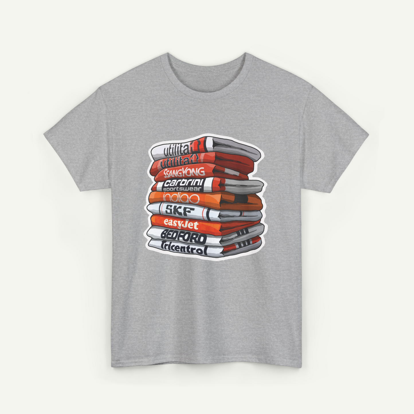 A gray t-shirt with a graphic design depicting a stack of books or magazines with various titles and text.