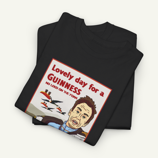 The image is a black t-shirt with a graphic design featuring a cartoon-style illustration of a man's face and the text "Lovely day for a Guinness" along with a humorous caption.