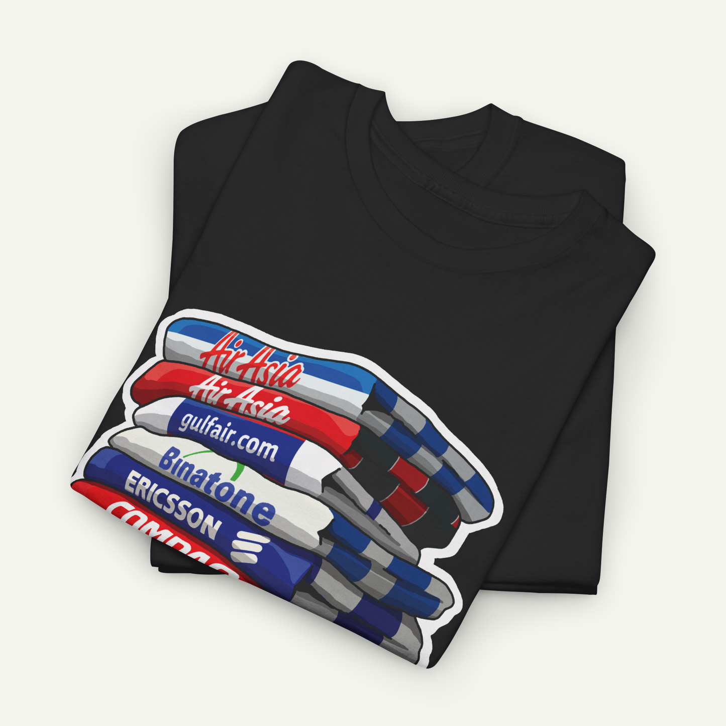 A black t-shirt with a graphic design depicting a stack of books or magazines with various text elements on the covers.