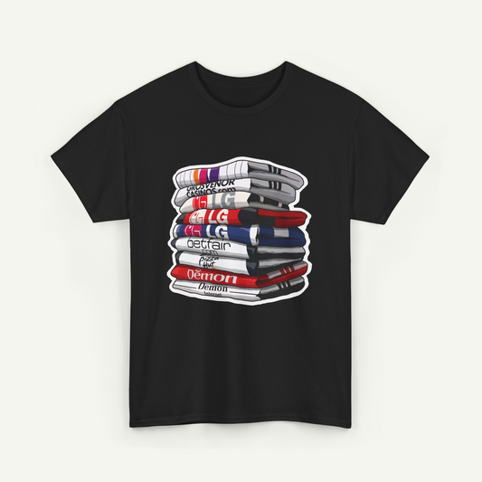 A black t-shirt with a graphic design depicting a stack of books or magazines with various text and logos on the covers.