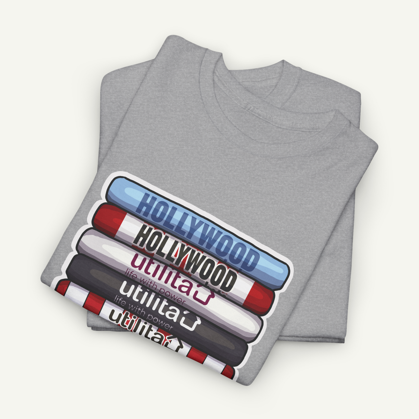 A gray t-shirt with a graphic design depicting the words "Hollywood" in various colors, including red, blue, and white, arranged in a stacked formation.