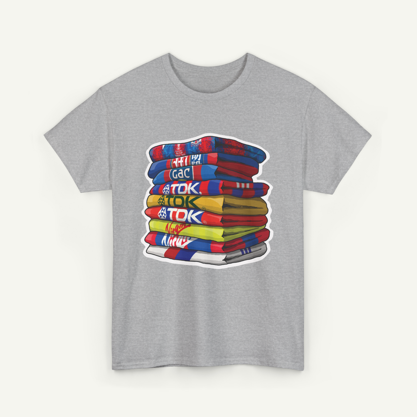 A gray t-shirt with a graphic design depicting a stack of colorful towels with various text written on them.