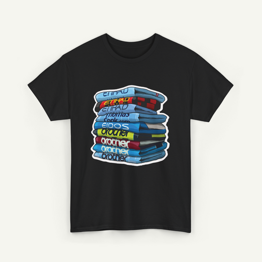 A black t-shirt with a graphic design depicting a stack of colorful books or magazines.