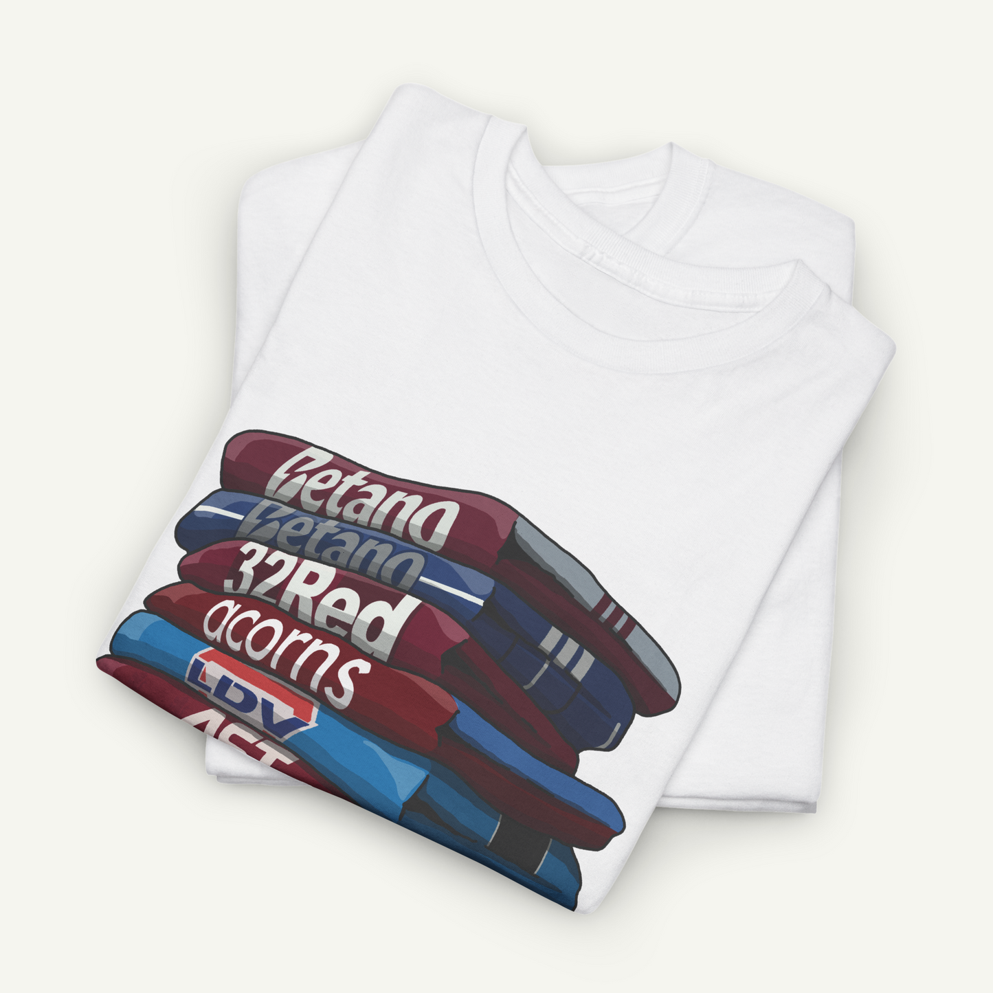 A white t-shirt with a graphic design depicting a stack of books or magazines with the titles "Betanal", "32Red", "acorns", and "LDV ACT" printed on it.