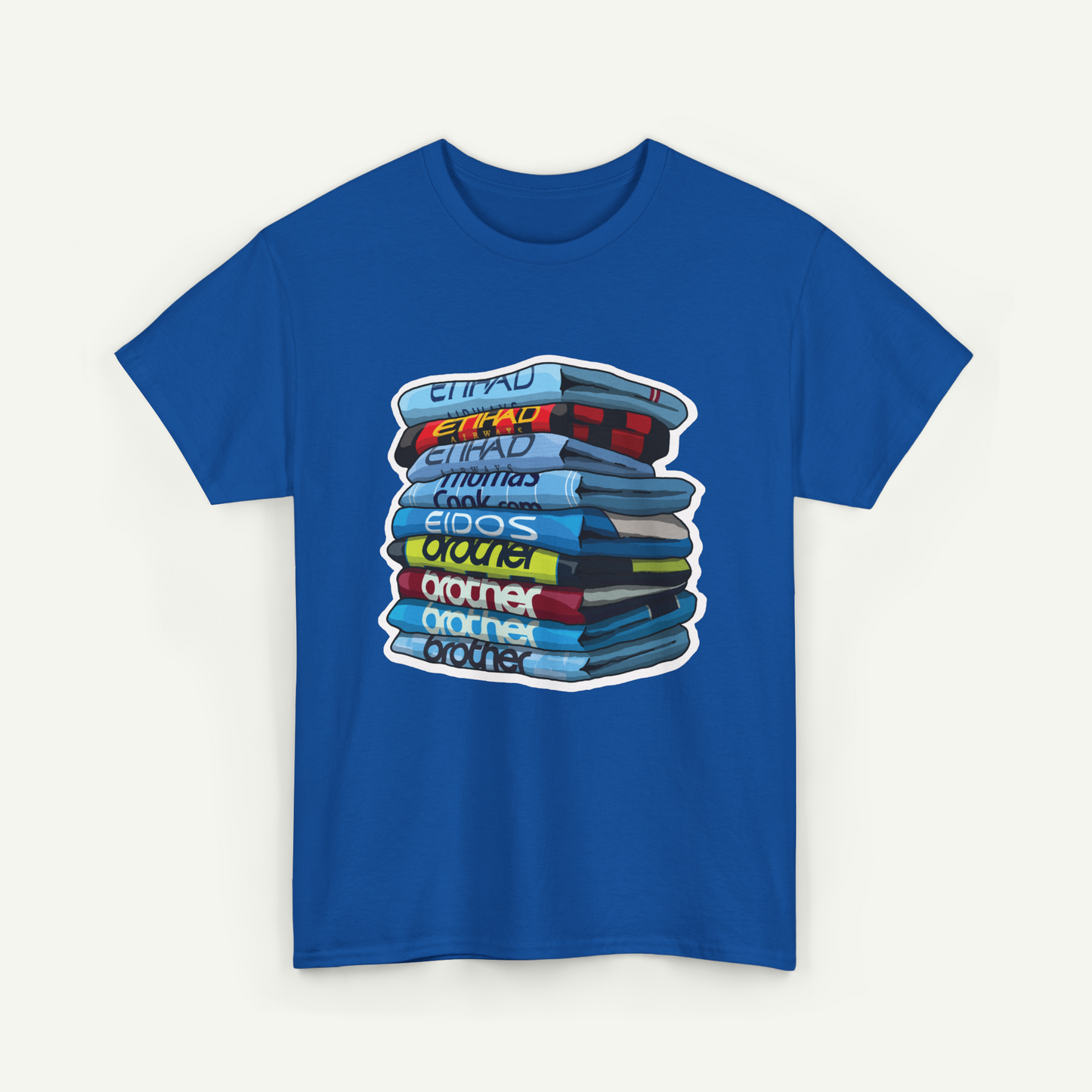 A blue t-shirt with a graphic design depicting a stack of books or magazines with various titles and colors.