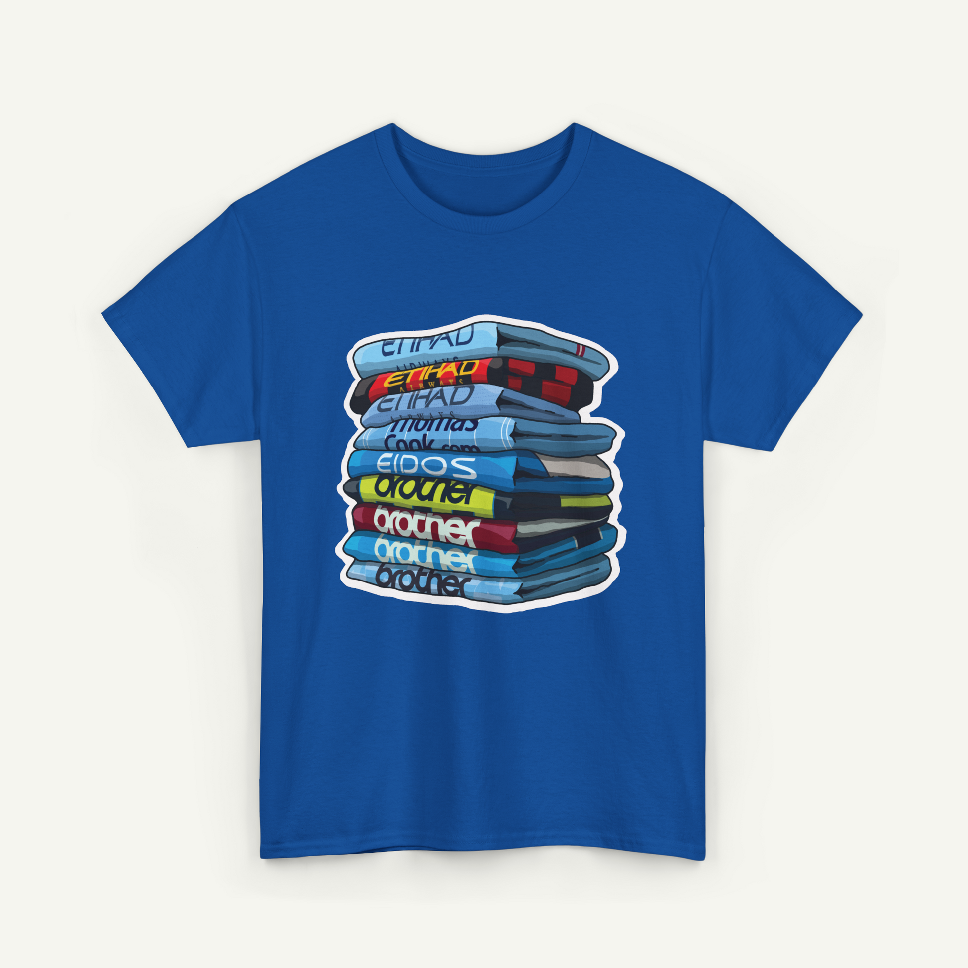 A blue t-shirt with a graphic design depicting a stack of books or magazines with various titles and colors.