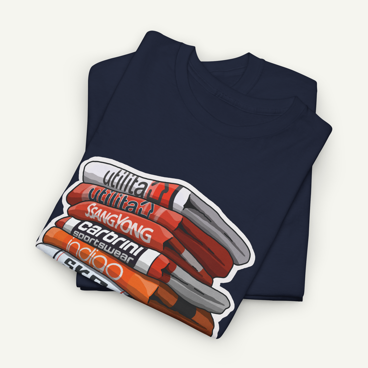 A navy blue t-shirt with a graphic design depicting a stack of books or magazines with various text titles.