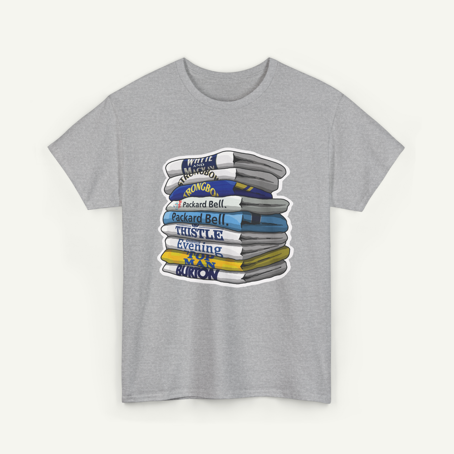 A gray t-shirt with a graphic design depicting a stack of books or magazines with various titles and text.