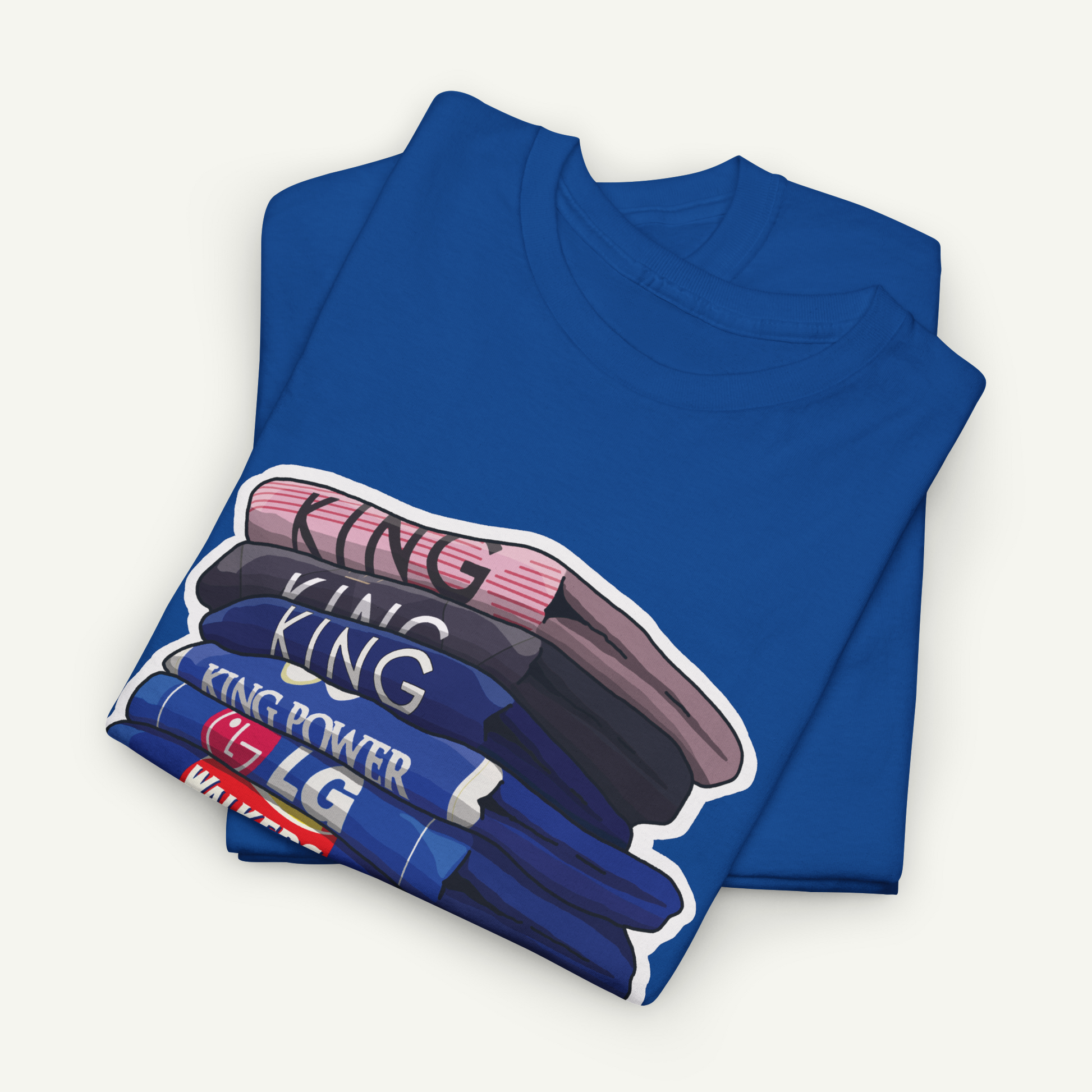 A blue t-shirt with a graphic design depicting a stack of various colored shirts, with the word "KING" prominently displayed on the shirts.