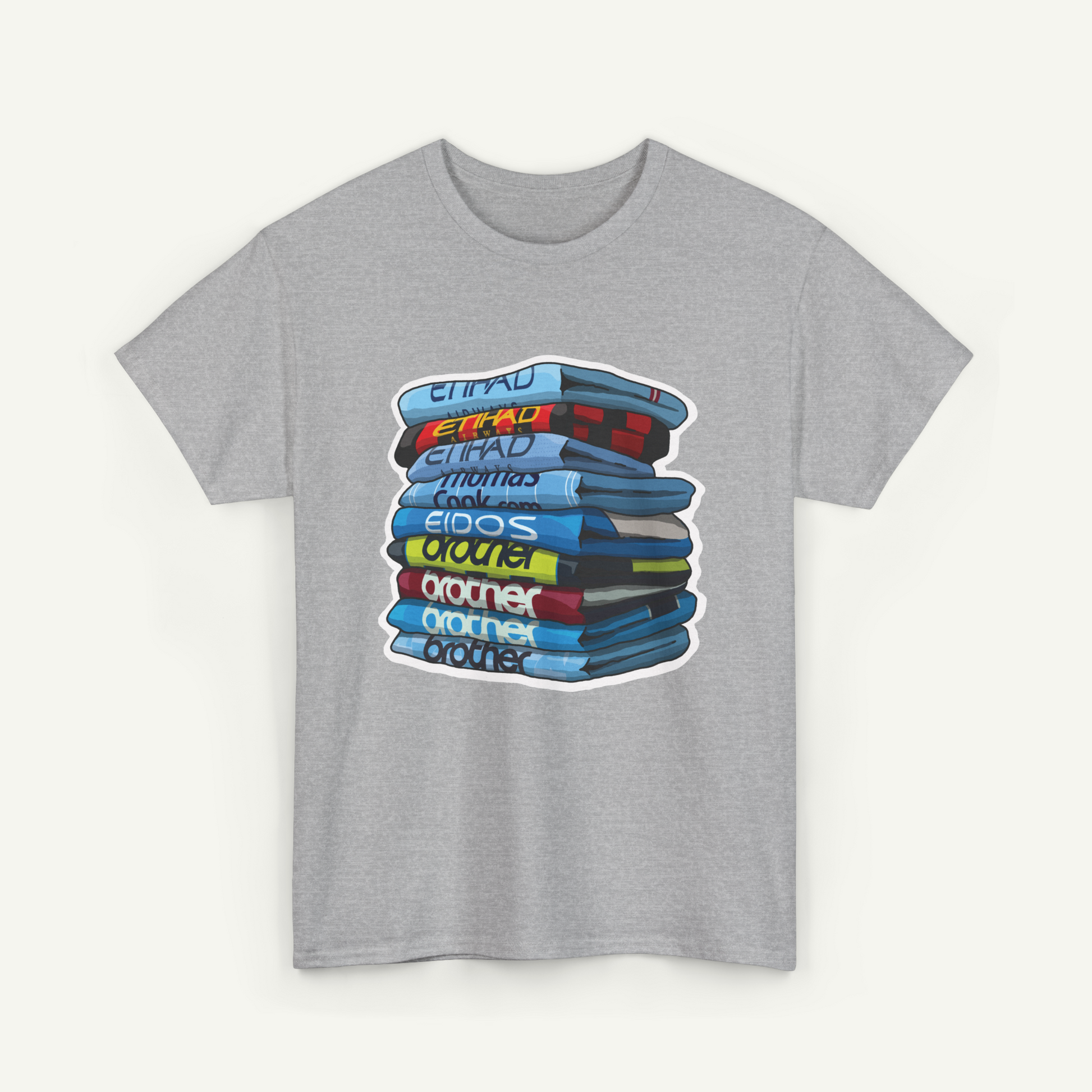 A gray t-shirt with a graphic design depicting a stack of colorful books or magazines.