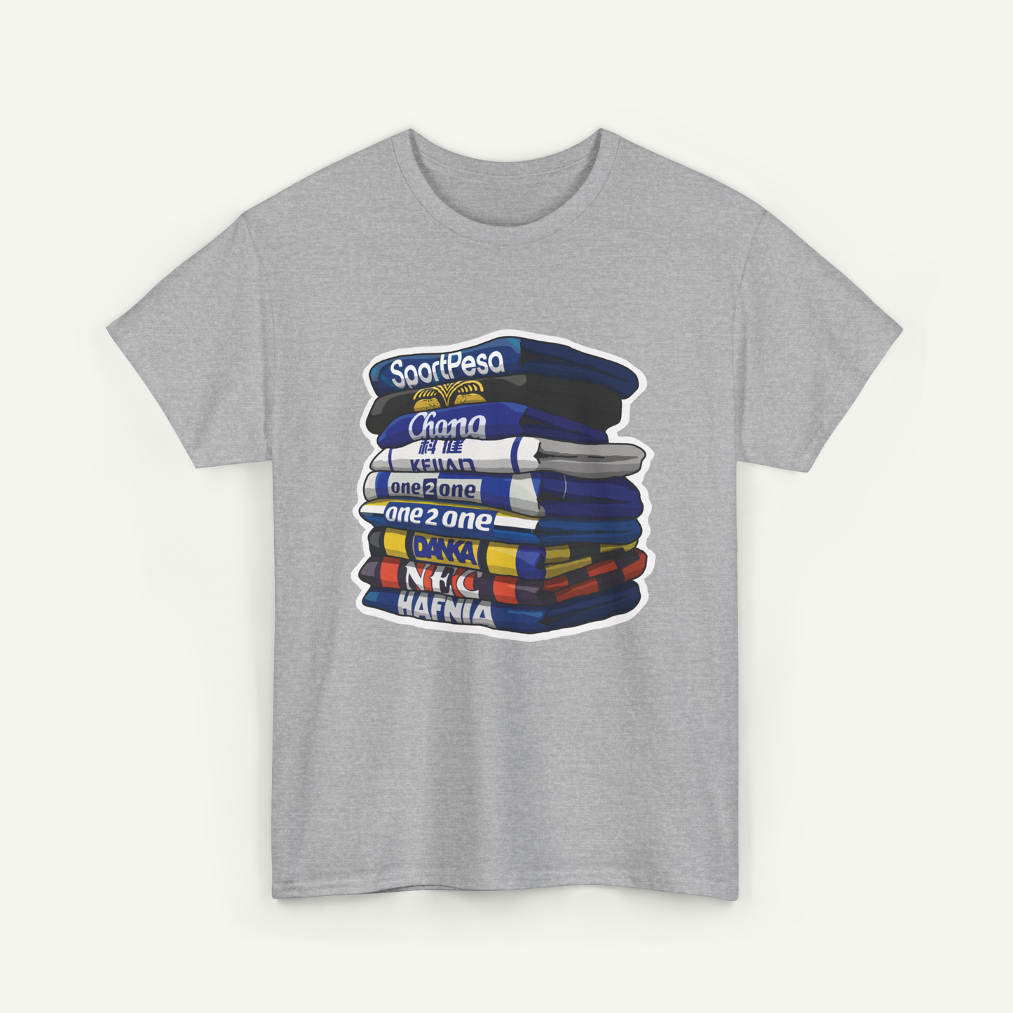 A gray t-shirt with a graphic design depicting a stack of books or magazines with various titles and text.