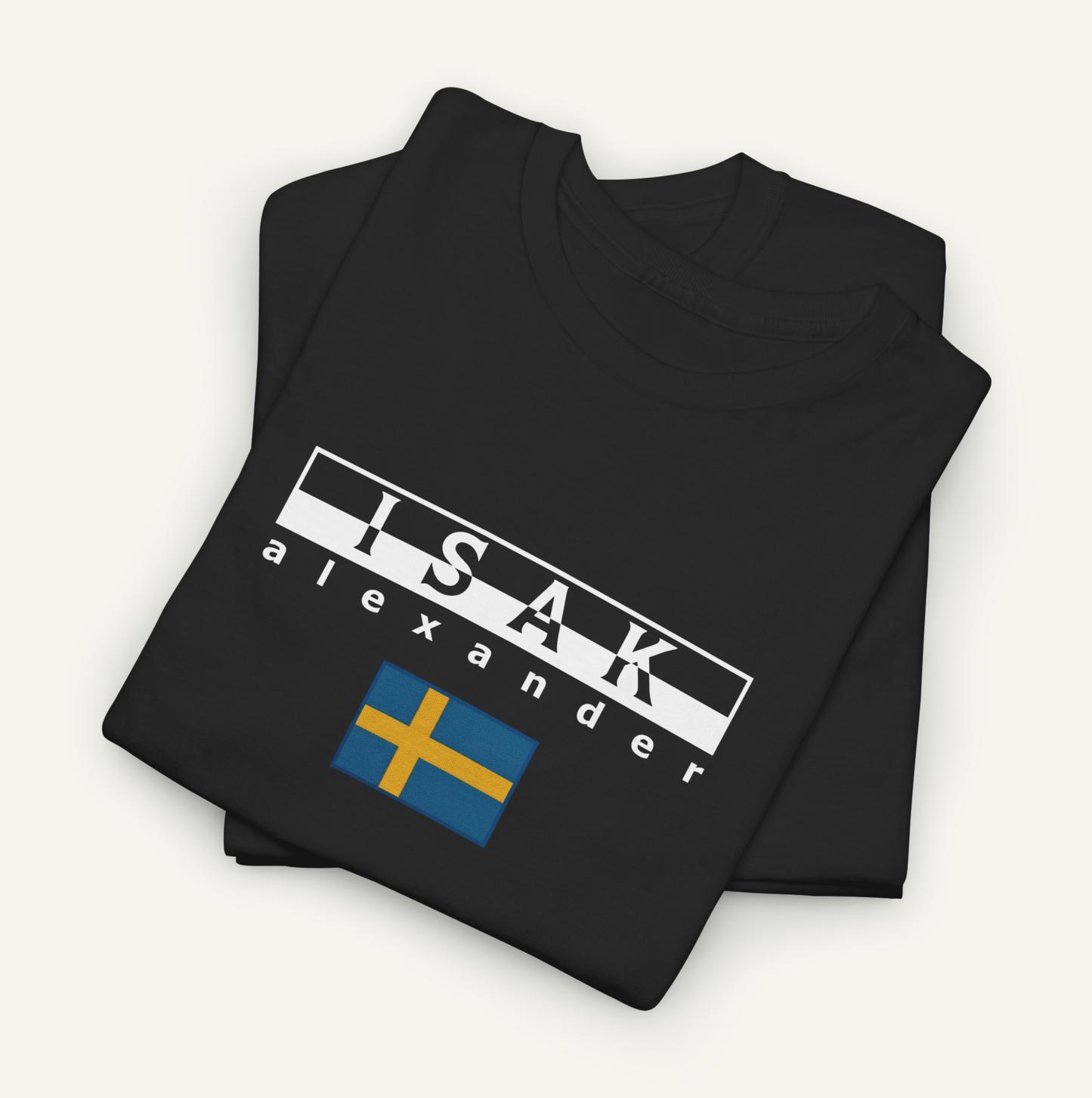 A black t-shirt with the text "ISAK Alexander" printed on it, along with a small flag design.