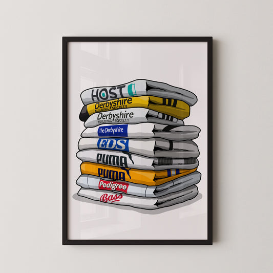 A framed illustration depicting a stack of various colored towels or blankets, each with a different logo or text printed on them.