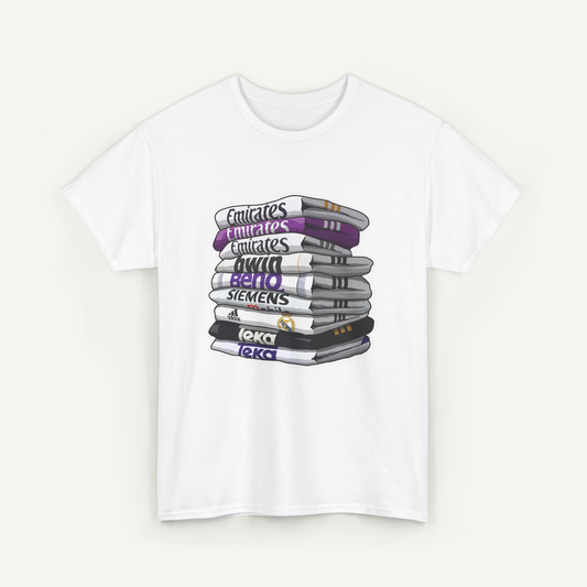 A white t-shirt with a graphic design depicting a stack of books with various text labels on the spines.